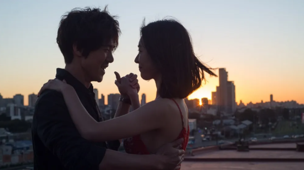 Cute asian couple dance at sunset with a city backdrop