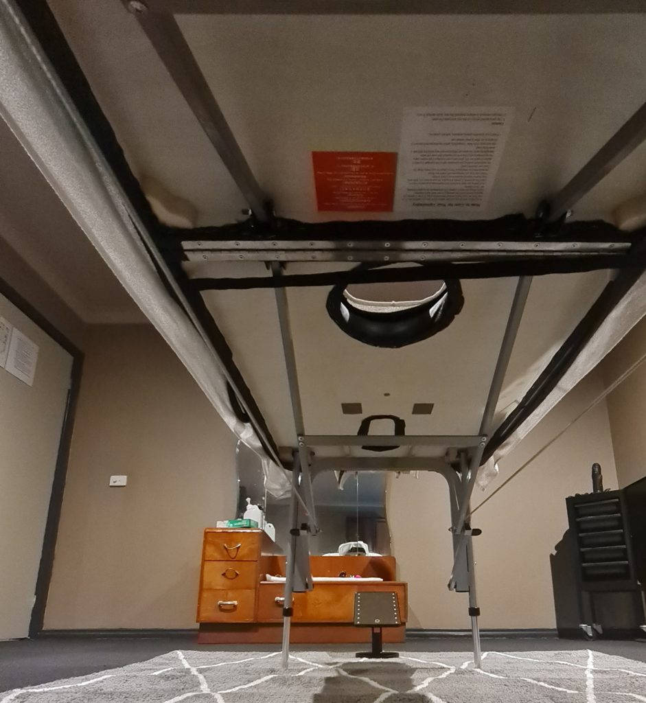 Underneath a custom firm 'n' fold milking table for erotic masage