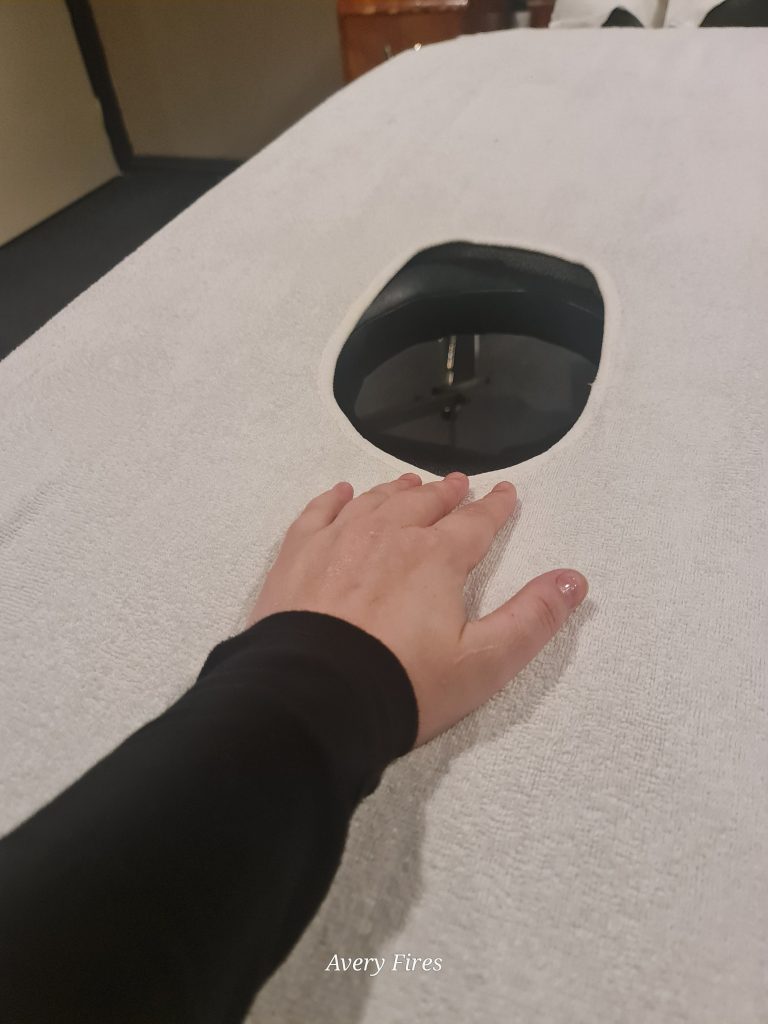 A hand placed next to the hole of a milking table.